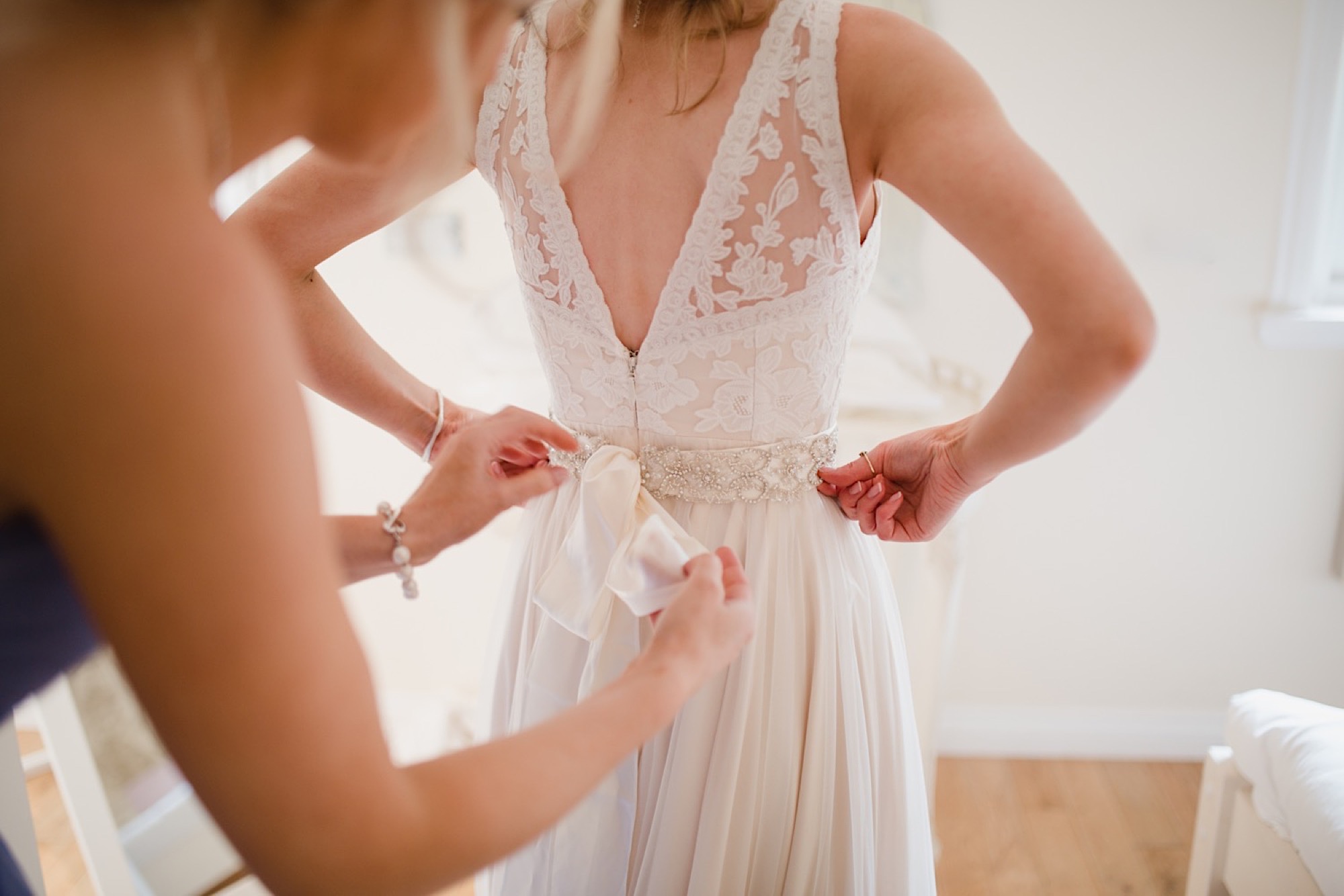 bride having her dress buttoned up cruin loch lomand